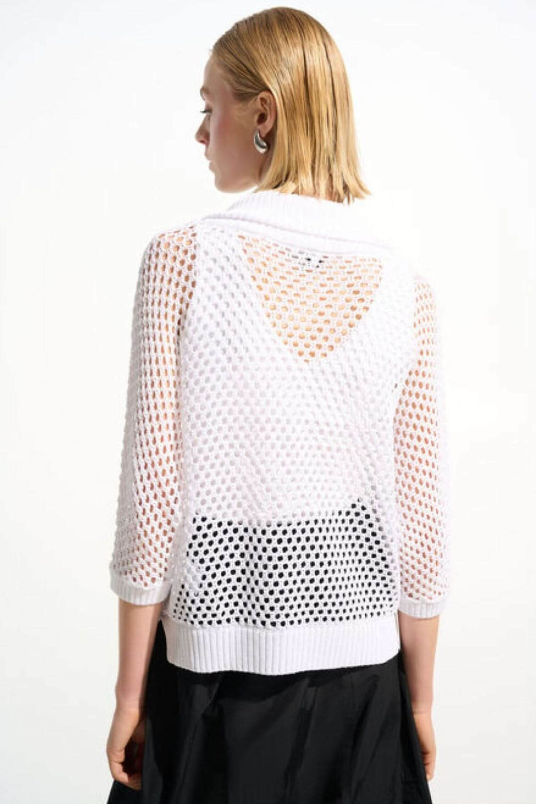 Femme portant un chandail ajouré à col zippé blanc avec manches trois-quarts, vue arrière montrant la maille ouverte élégante.