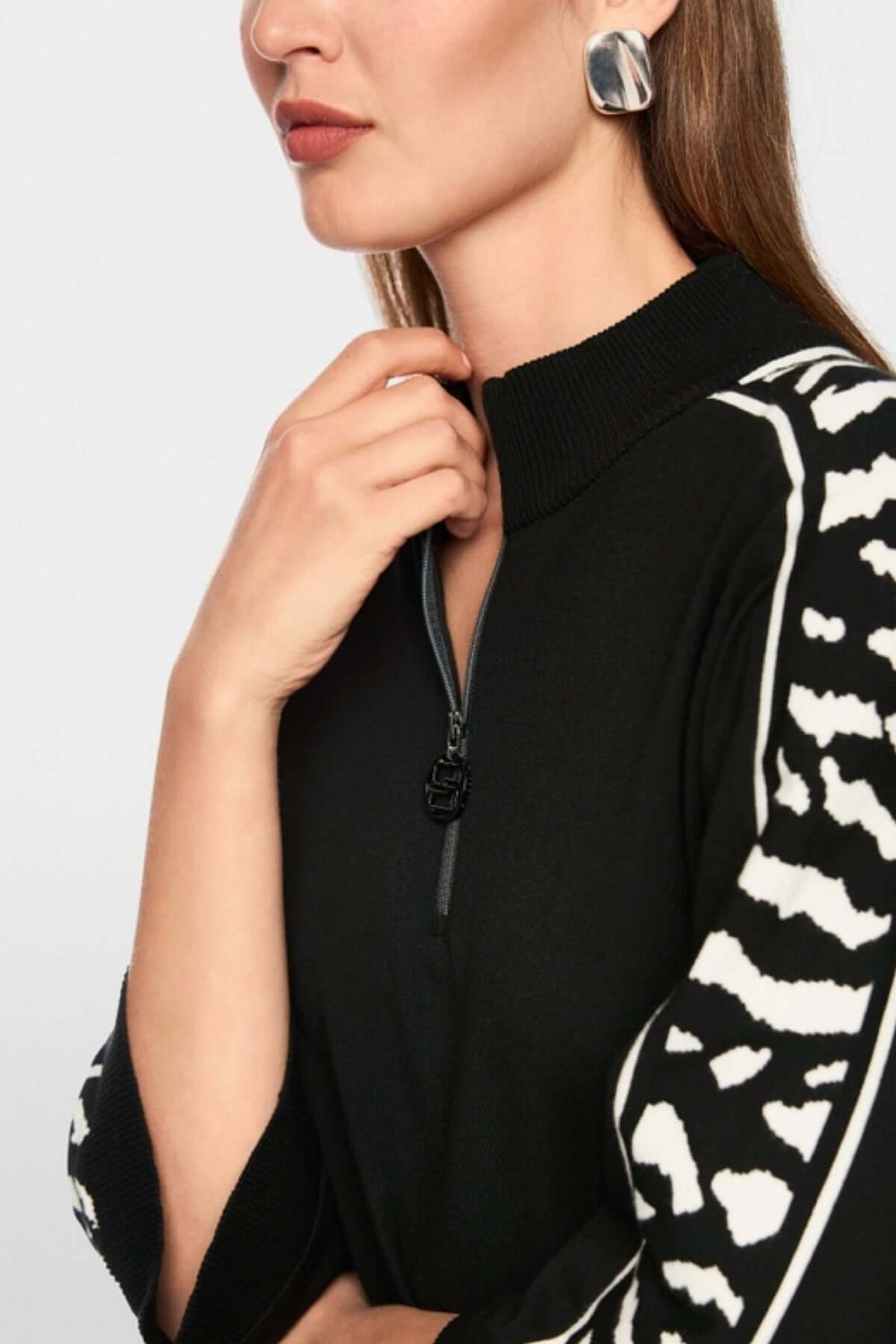 Femme portant un chandail ample avec manches 3/4 et motif animalier, fermeture à glissière au col. Label « Rethink Together ».