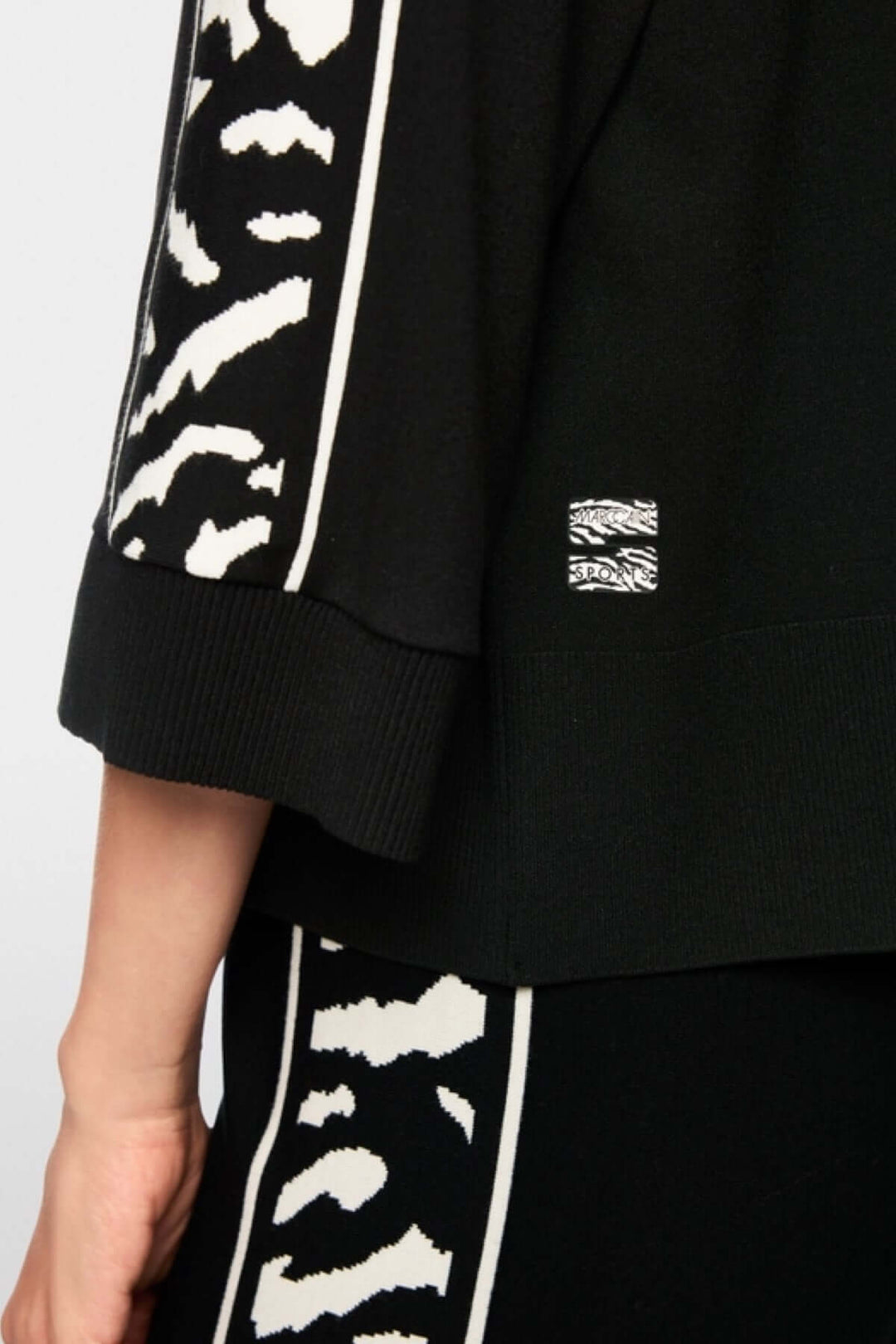 Chandail ample noir avec manches 3/4 et motif animalier contrasté, bord-côtes au col et ourlet, label de durabilité « Rethink Together ».