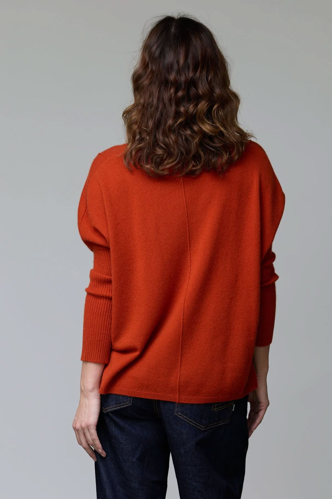 Chandail ample couleur orange à col rond et coutures apparentes, avec manches tombantes, chic et confortable pour l'automne.