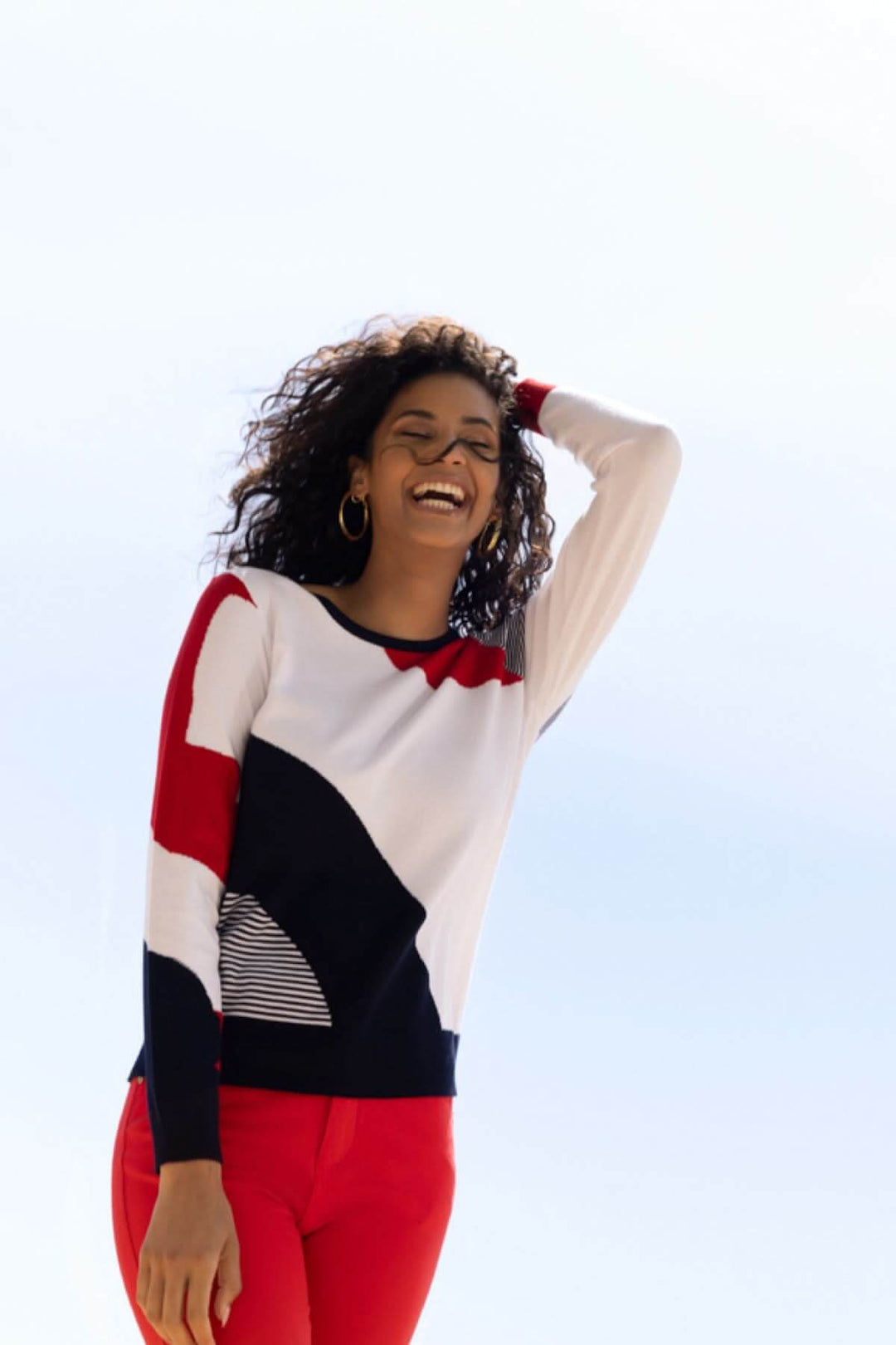 Femme portant un chandail au motif graphique avec des couleurs contrastantes, idéal pour une tenue décontractée et élégante.