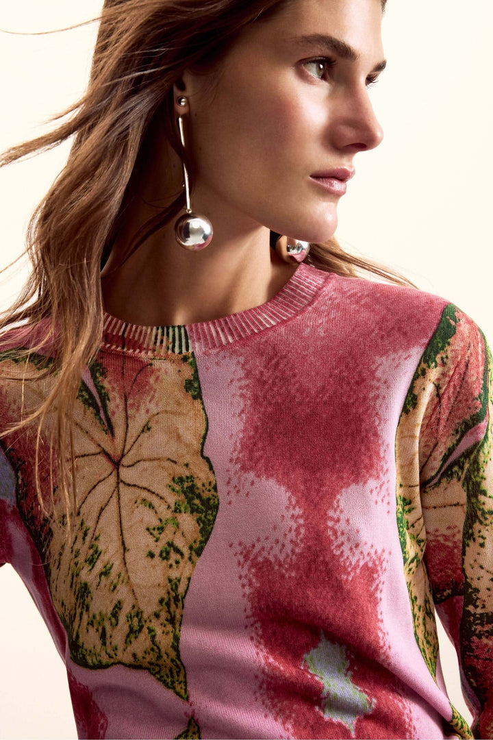 Femme portant un chandail avec motif graphique inspiré du monde végétal, à manches longues et coupe ajustée.