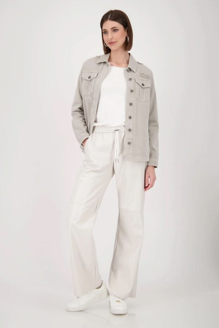 Femme portant un chandail basique à manches longues, en jean, avec un pantalon blanc élégant.