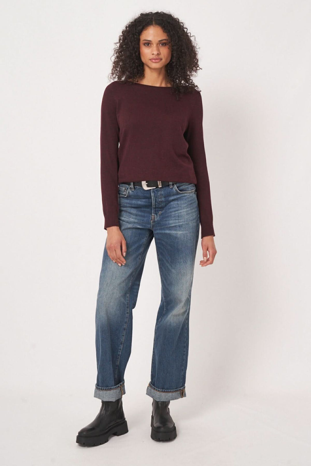 Chandail basique à encolure bateau en bordeaux, porté avec un jean bleu délavé pour un look décontracté.