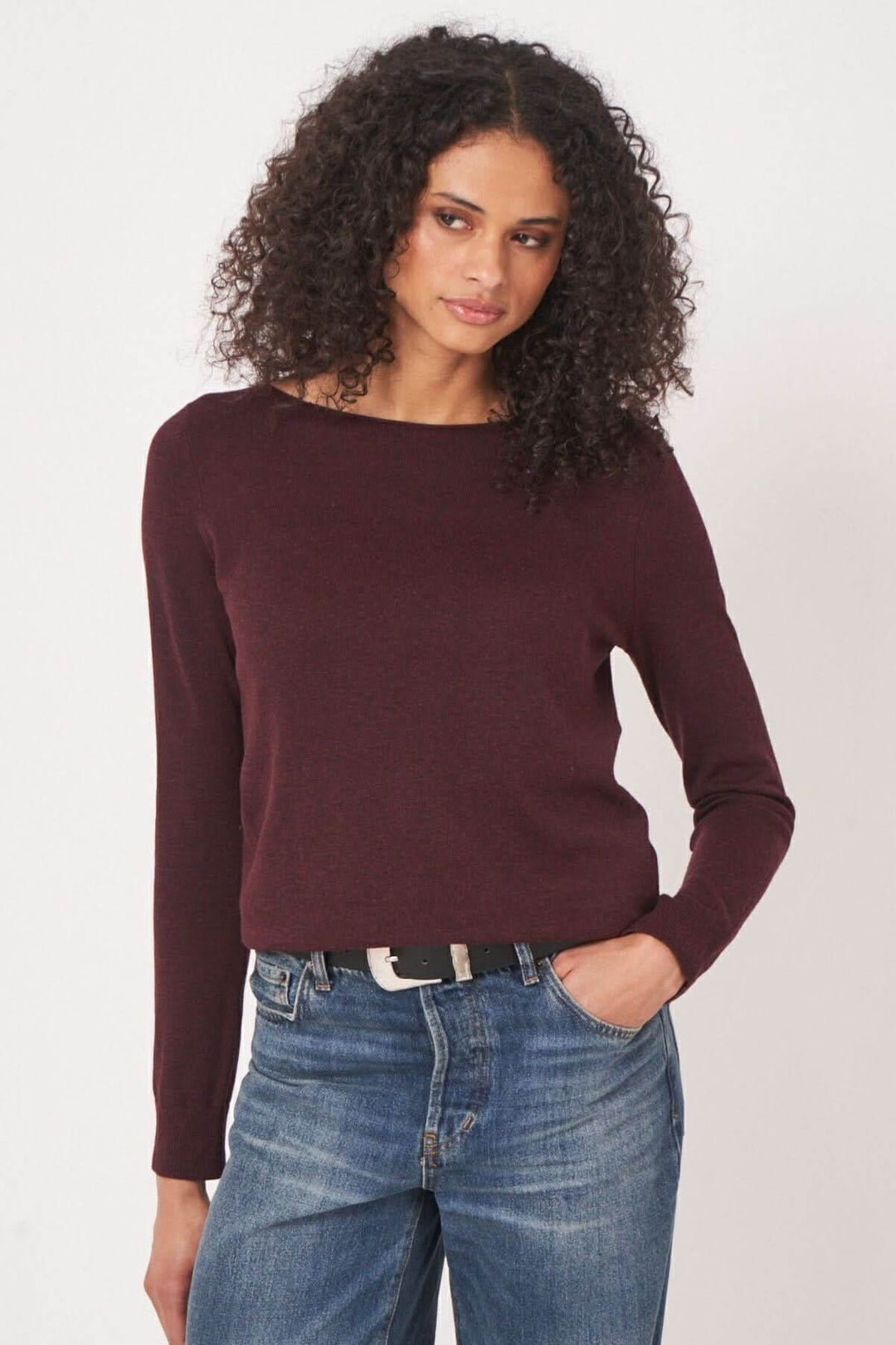 Chandail basique bordeaux à encolure bateau, coupe droite, porté avec un jean bleu pour un look décontracté.