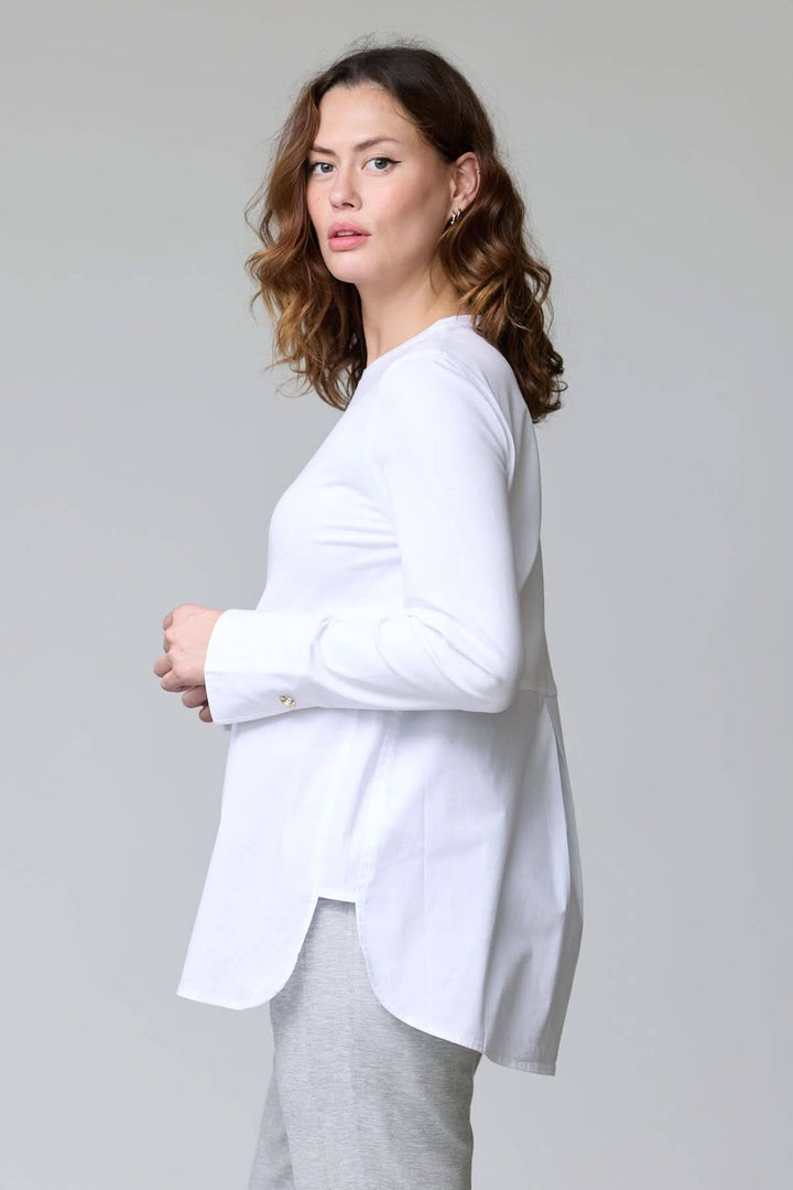 Femme portant un chandail à boutons décoratifs blanc avec manches longues, style chic décontracté.