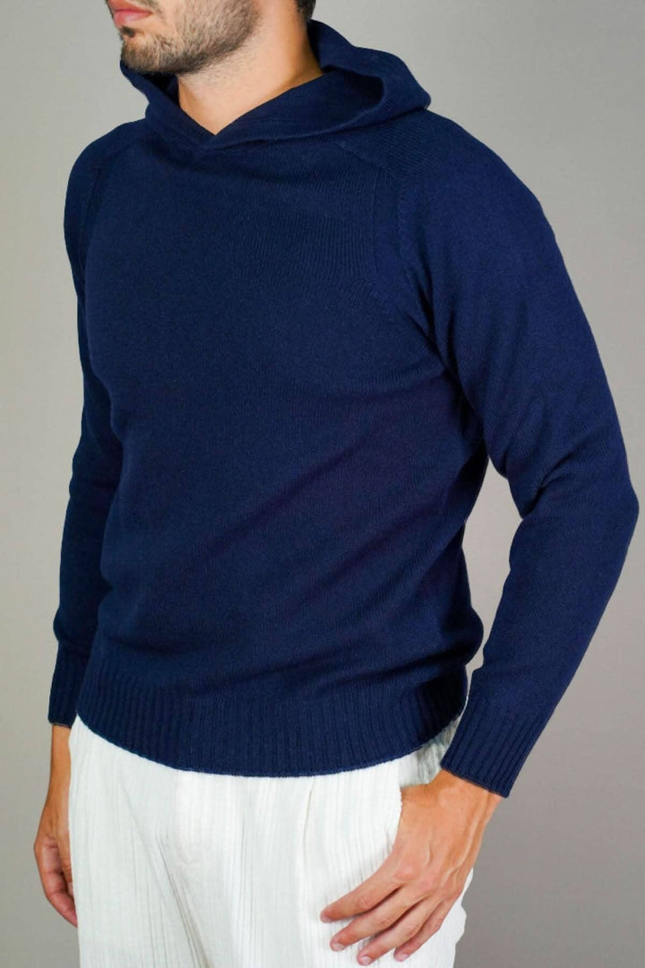 Homme portant un chandail à capuchon en laine Super Geelong, couleur bleu marine, associé à un pantalon léger.