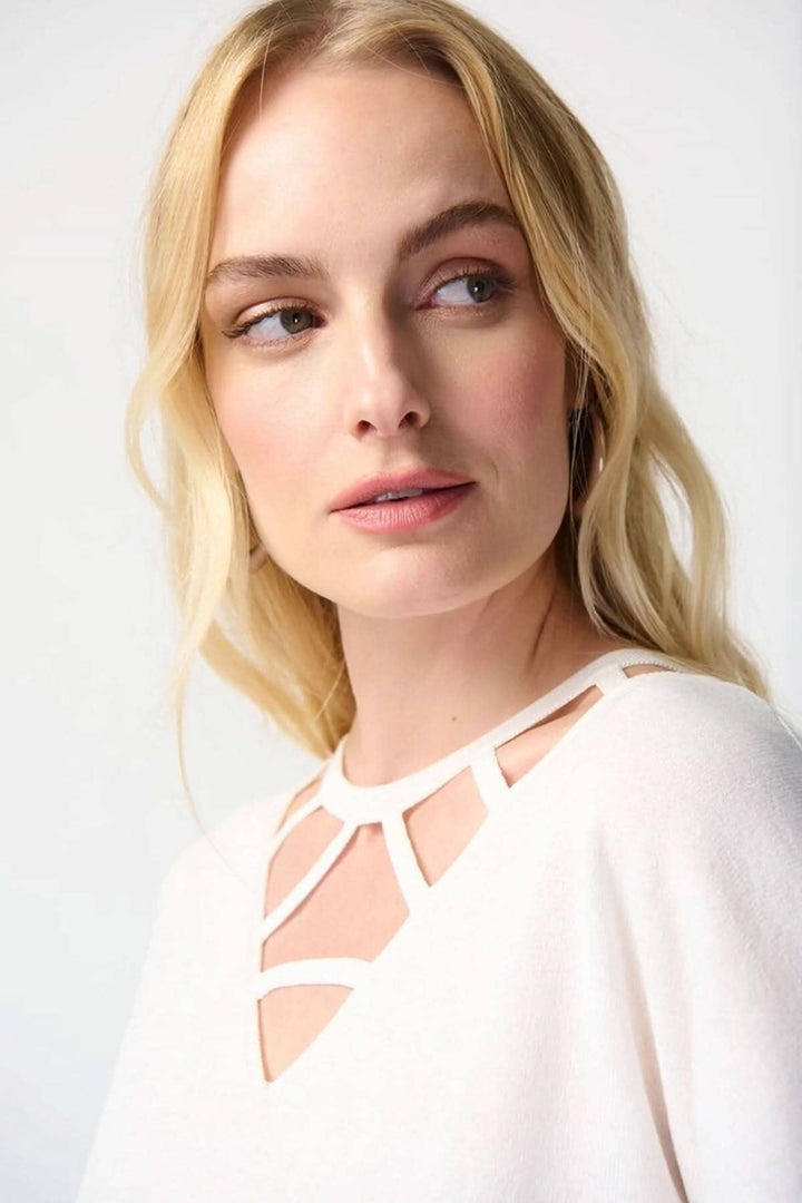 Femme portant un chandail col en V avec détails découpés et manches courtes, style élégant et moderne.