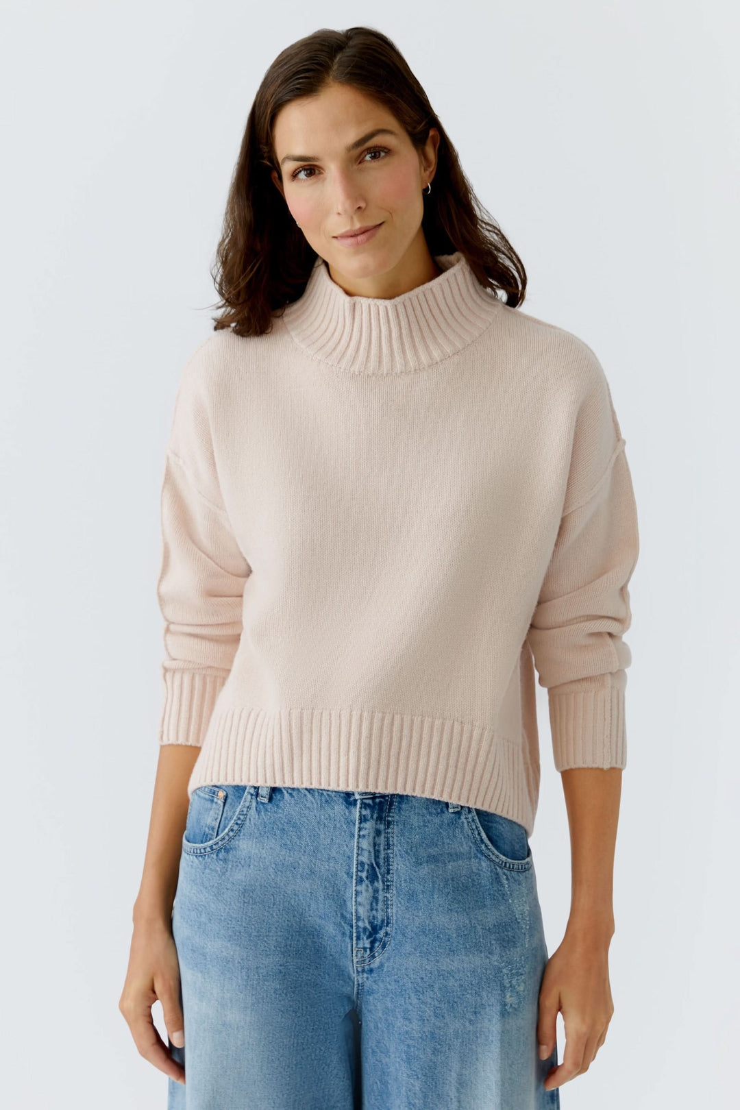 Femme portant un Chandail à col montant en maille douce couleur crème.