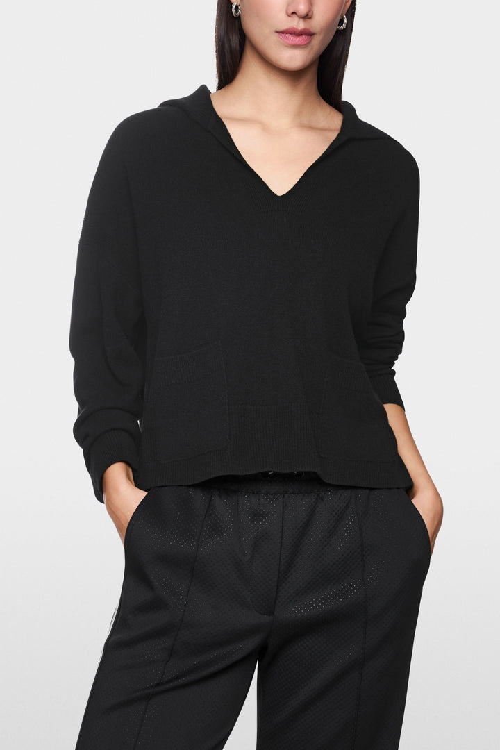 Chandail col ouvert noir avec poches, coupe droite décontractée, manches longues, élégant et moderne.