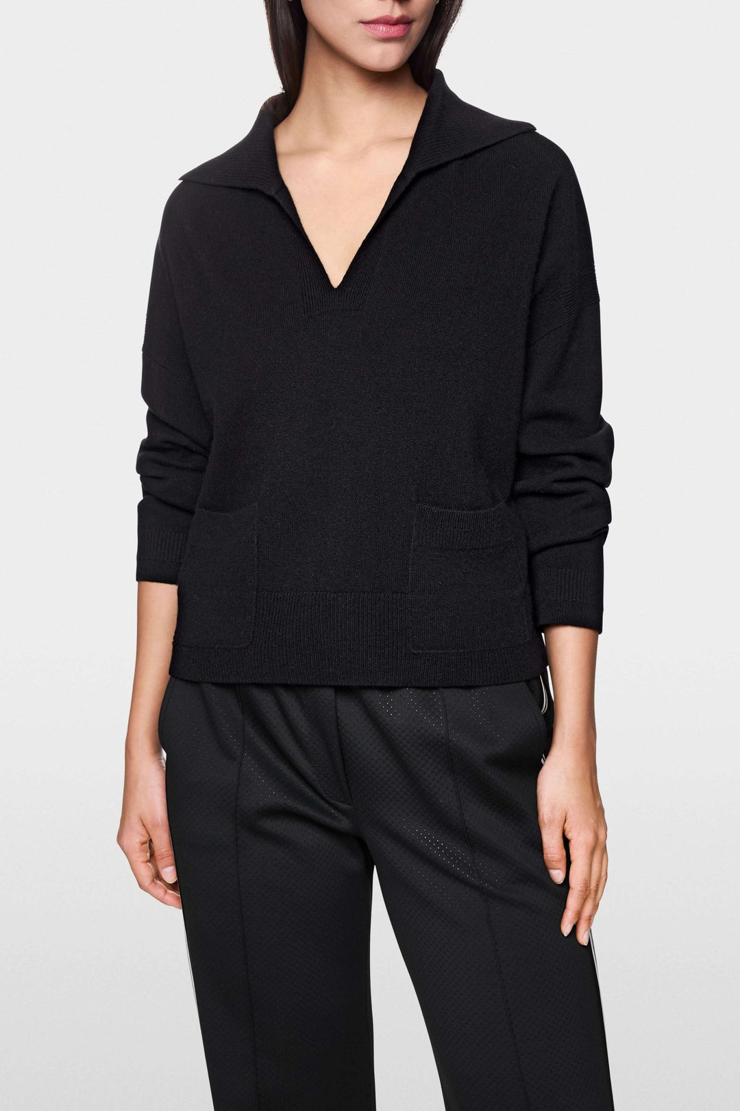 Chandail col ouvert noir avec poches plaquées et manches longues pour un style décontracté et chic.