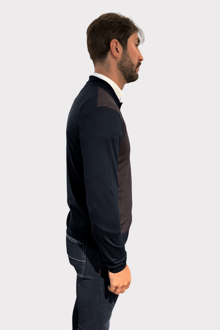 Homme portant un chandail à col polo moderne avec motif géométrique, vu de profil.