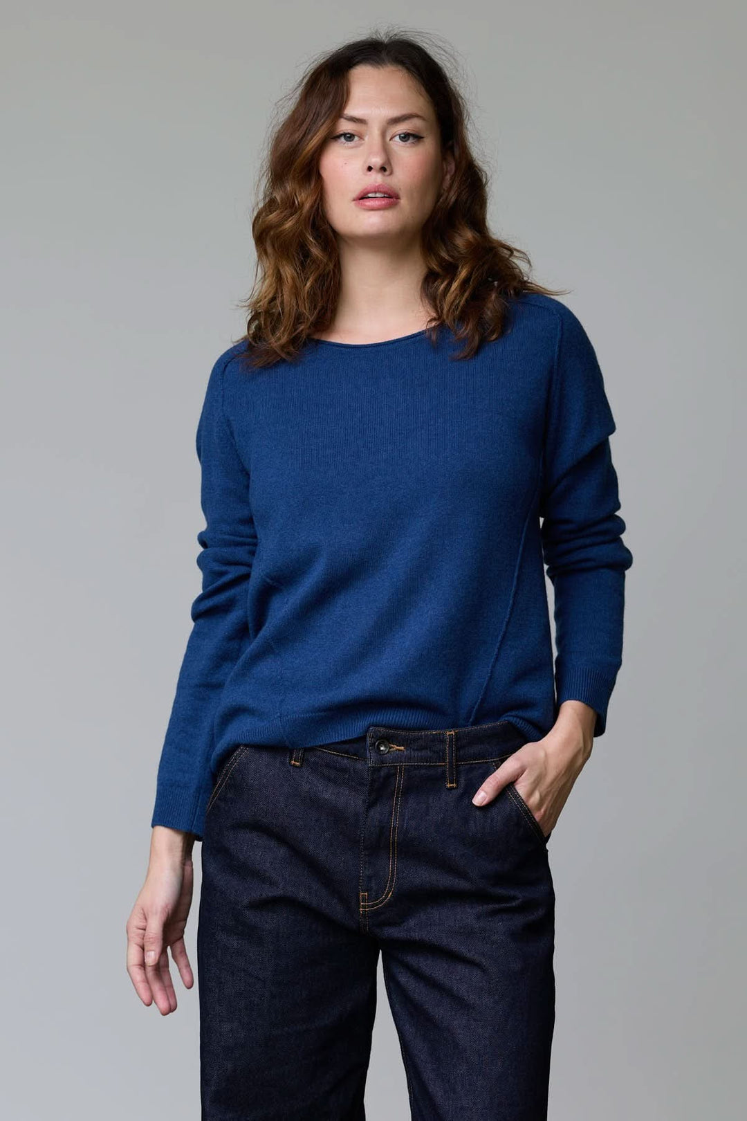 Femme portant un chandail à col rond bleu, coupe classique, maille fine et douce. Chandail à col rond élégant et confortable.