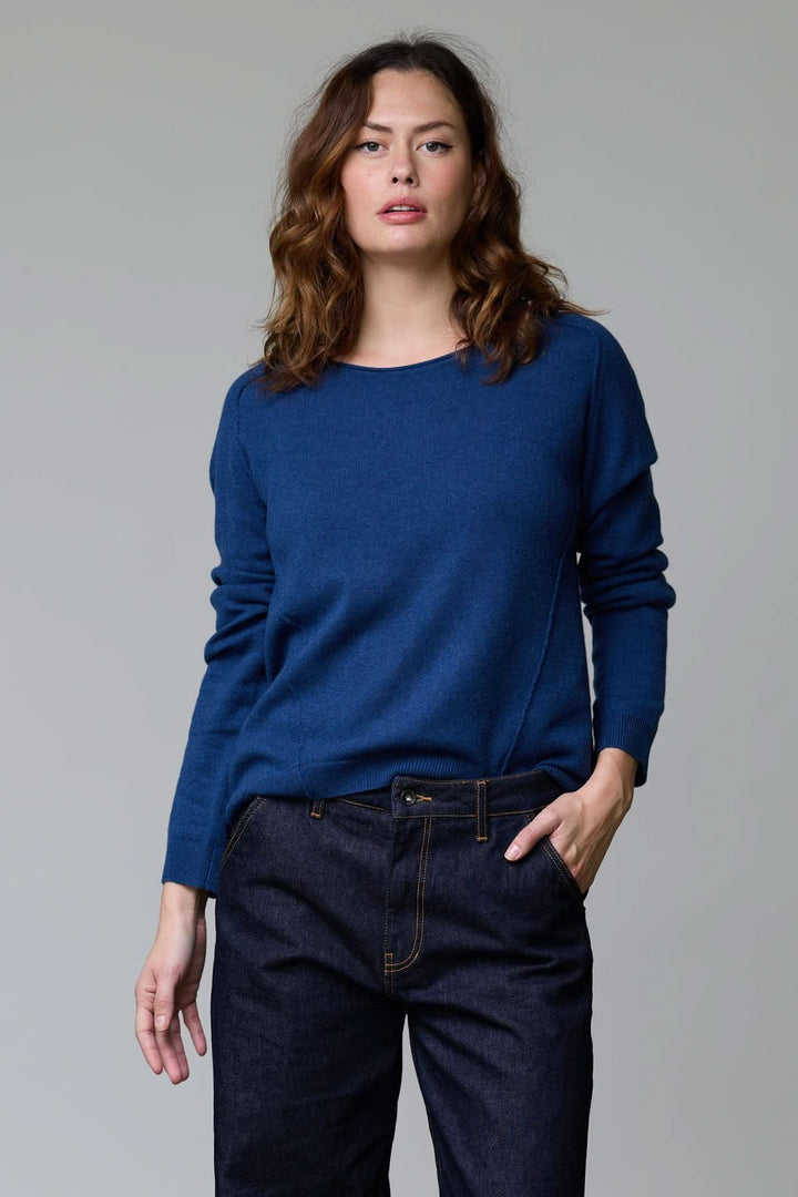 Femme portant un chandail à col rond bleu, coupe classique, maille fine et douce. Chandail à col rond élégant et confortable.