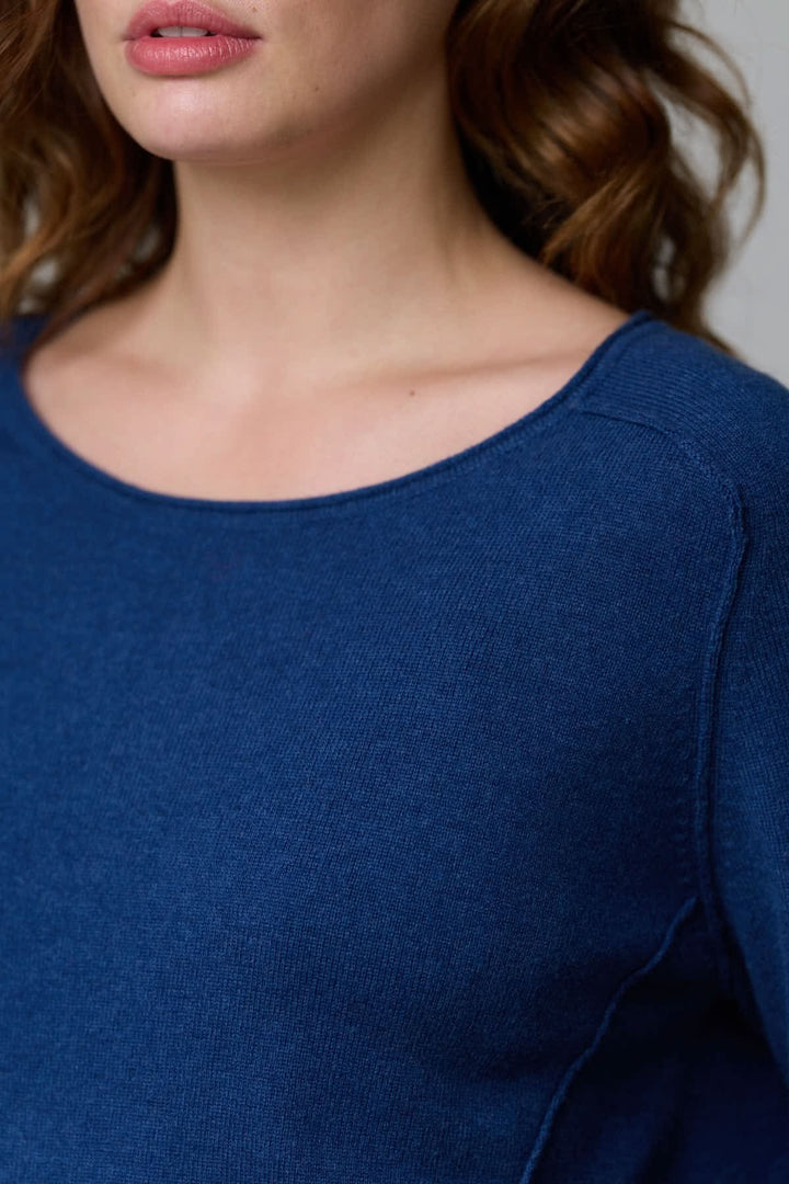 Femme portant un chandail à col rond en maille fine de couleur bleue, confort et élégance.