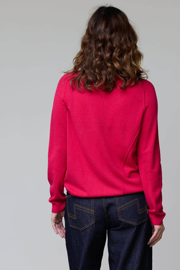 Vue arrière d'un chandail à col rond rouge porté avec un jean, soulignant sa coupe féminine et ses finitions côtelées.