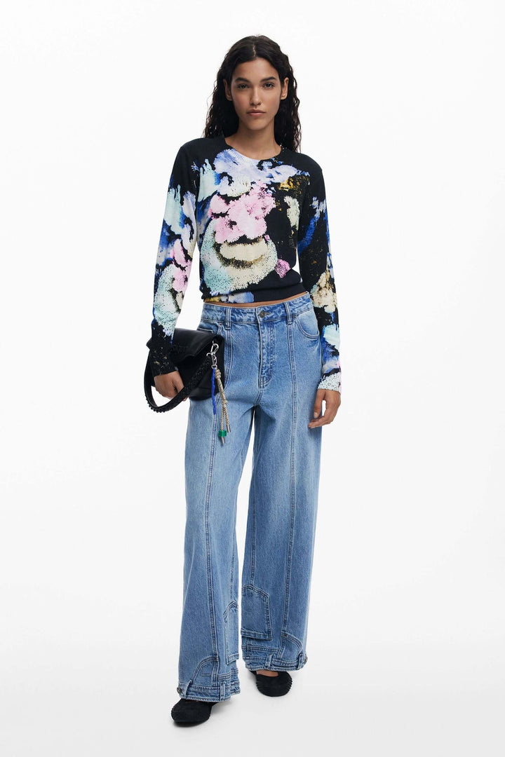 Chandail à col rond avec imprimé floral abstrait, porté avec un pantalon taille haute pour un look équilibré et confortable.