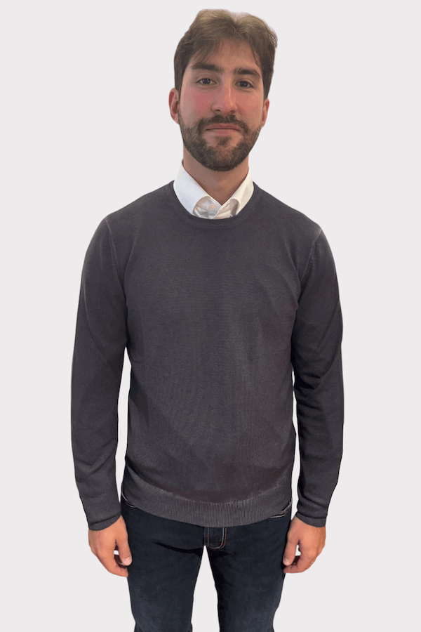 Homme portant un chandail col rond en laine, style moderne et coupe ajustée, sur fond blanc.
