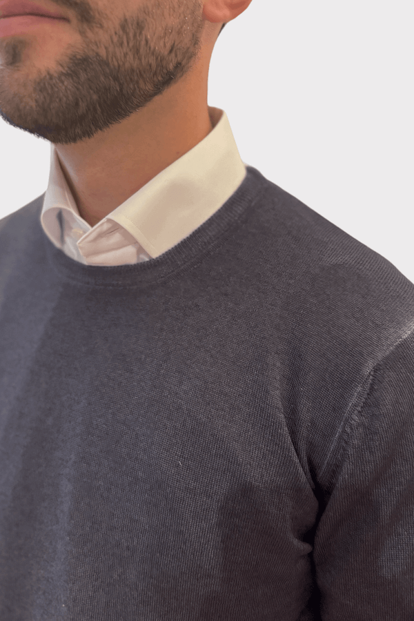 Chandail col rond de laine porté par un homme avec une chemise blanche, accentuant confort et style.