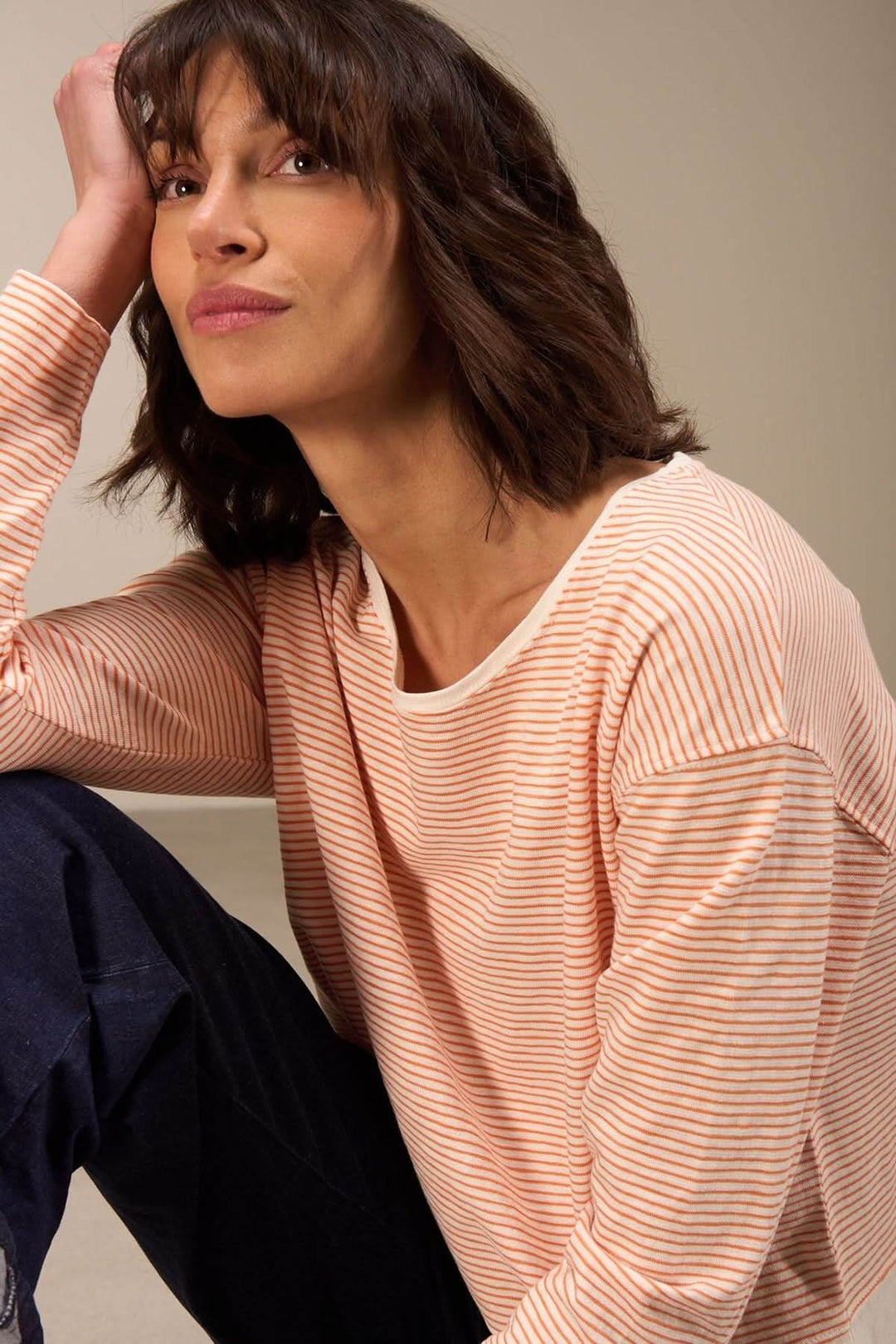 Chandail décontracté à manches longues en coton biologique, à rayures, porté par une femme, style casual chic.