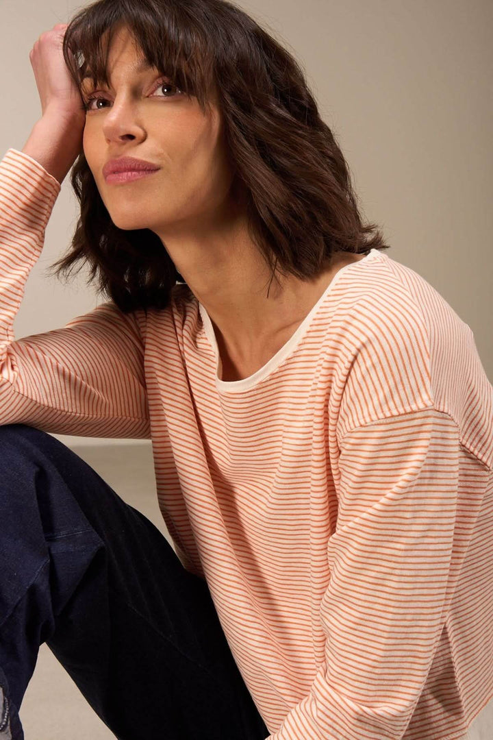 Chandail décontracté à manches longues en coton biologique, à rayures, porté par une femme, style casual chic.