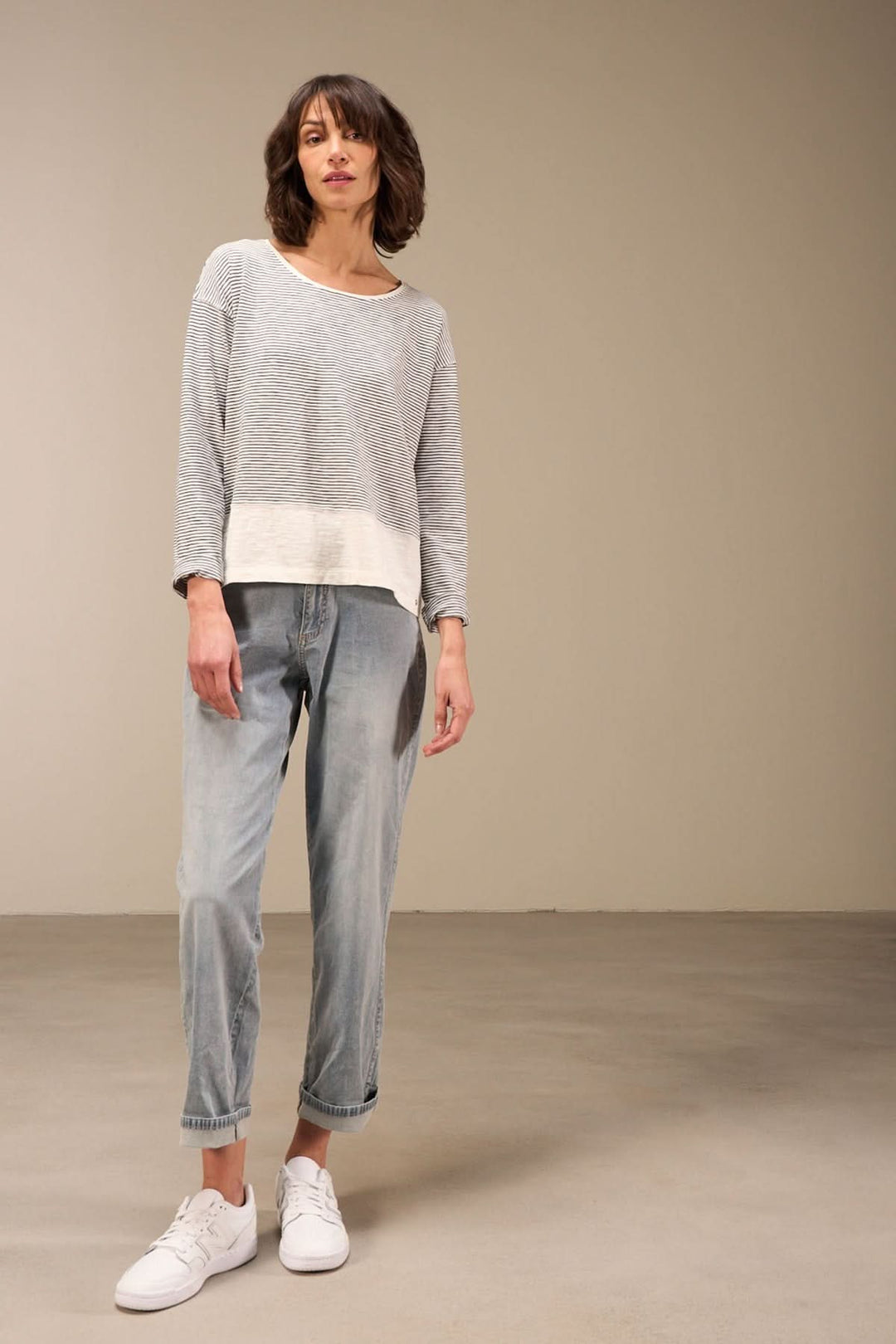 Chandail décontracté à manches longues en coton bio, col rond, porté avec un jean et des sneakers pour un style casual chic.