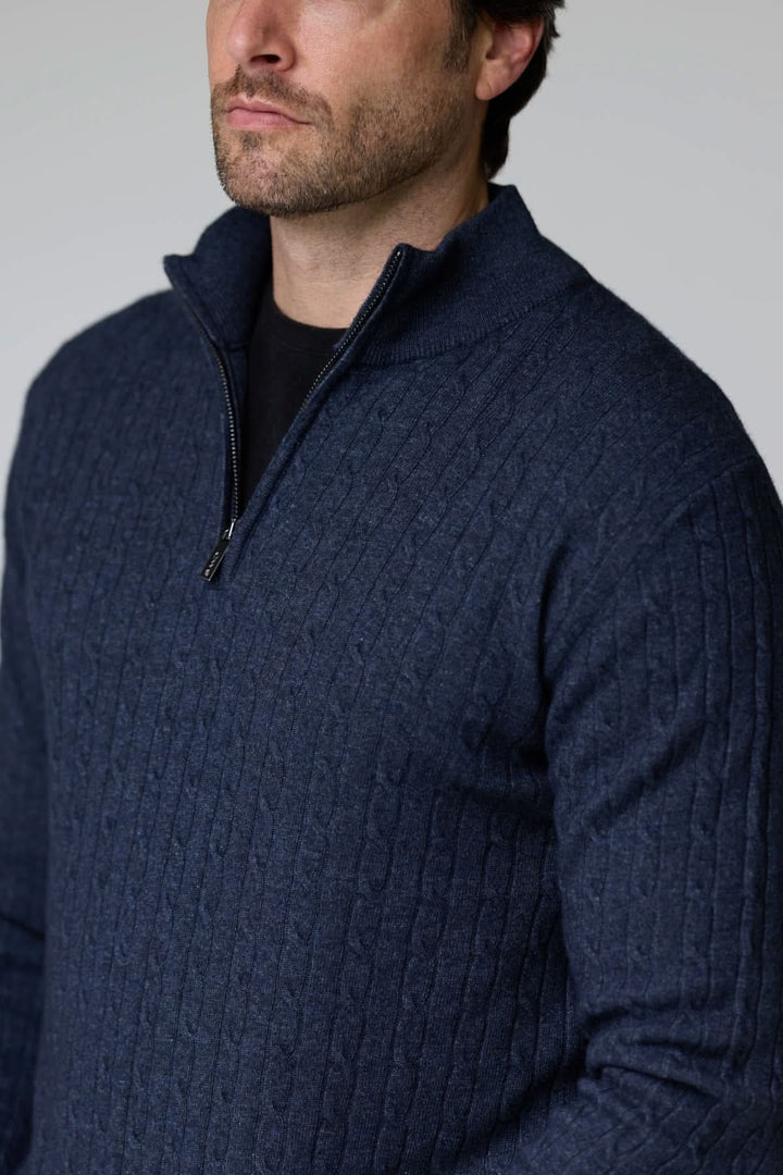 Homme portant un chandail à demi-glissière torsadé en laine, couleur marine, avec motif torsadé classique, style élégant et décontracté.