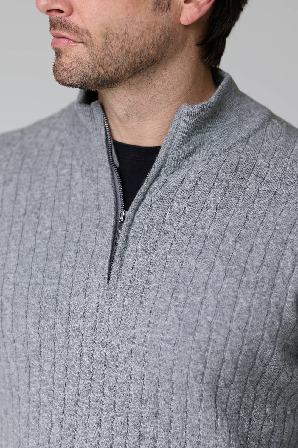 Homme portant un chandail à demi-glissière torsadé en laine gris, texture élégante et décontractée, col montant, maille chaude.