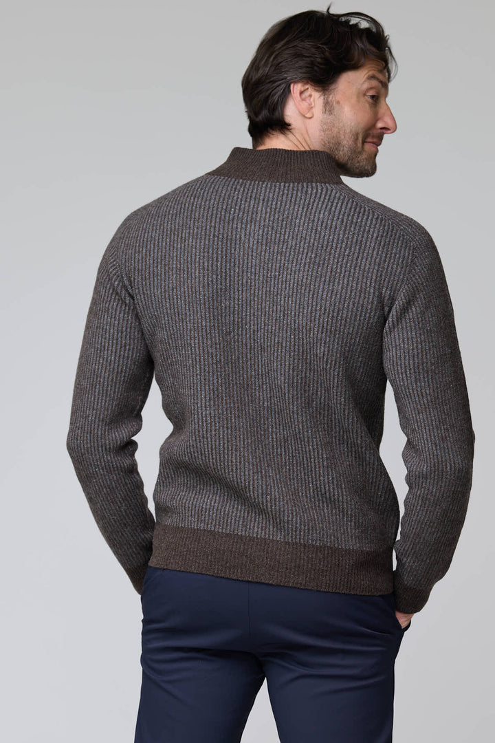Homme portant un chandail à demi-glissière torsadé en laine mérinos, motif élégant, col montant, ourlets et poignets côtelés.