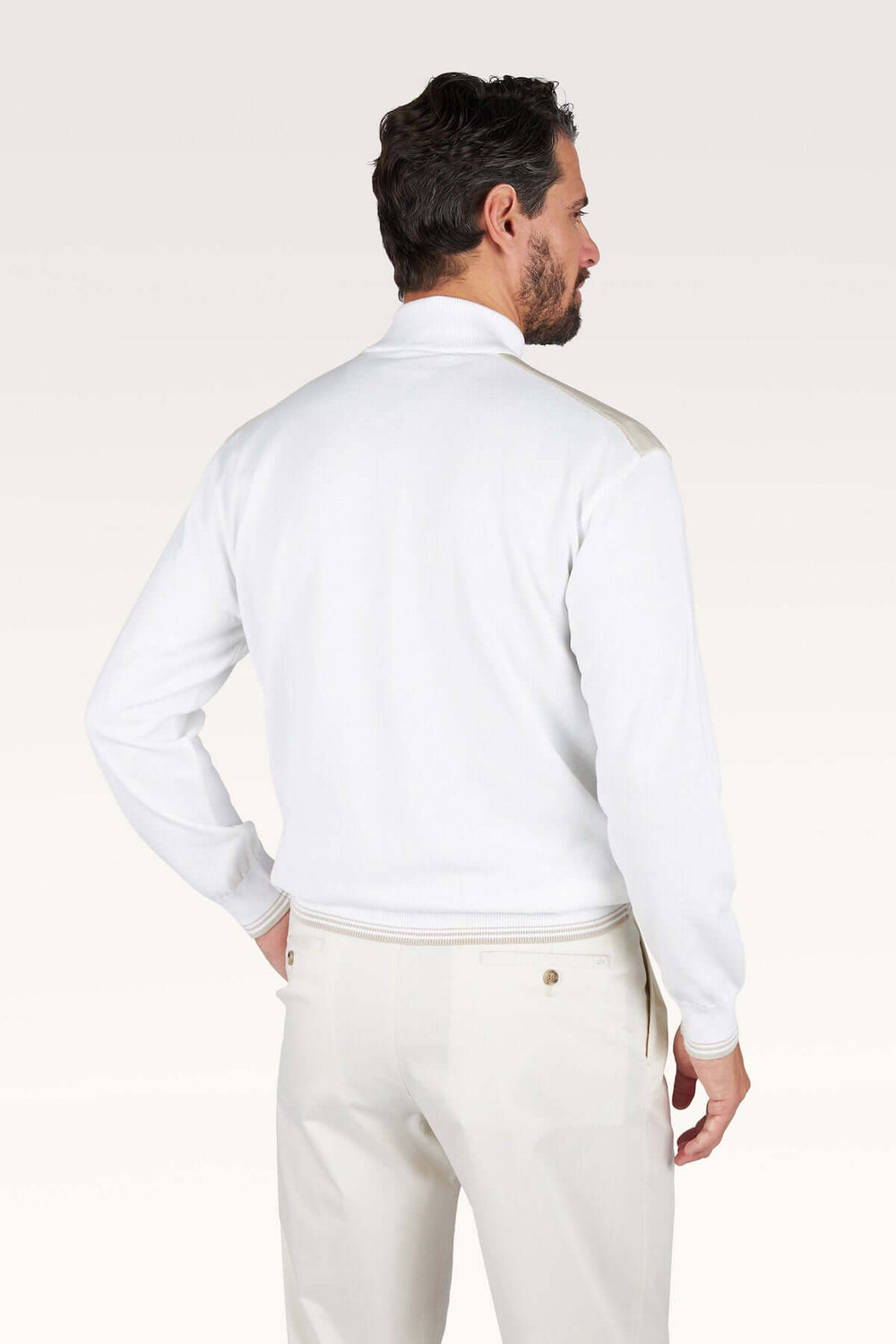 Homme portant un chandail à demi-zip blanc, vu de dos, avec col montant et coupe droite, style décontracté chic.