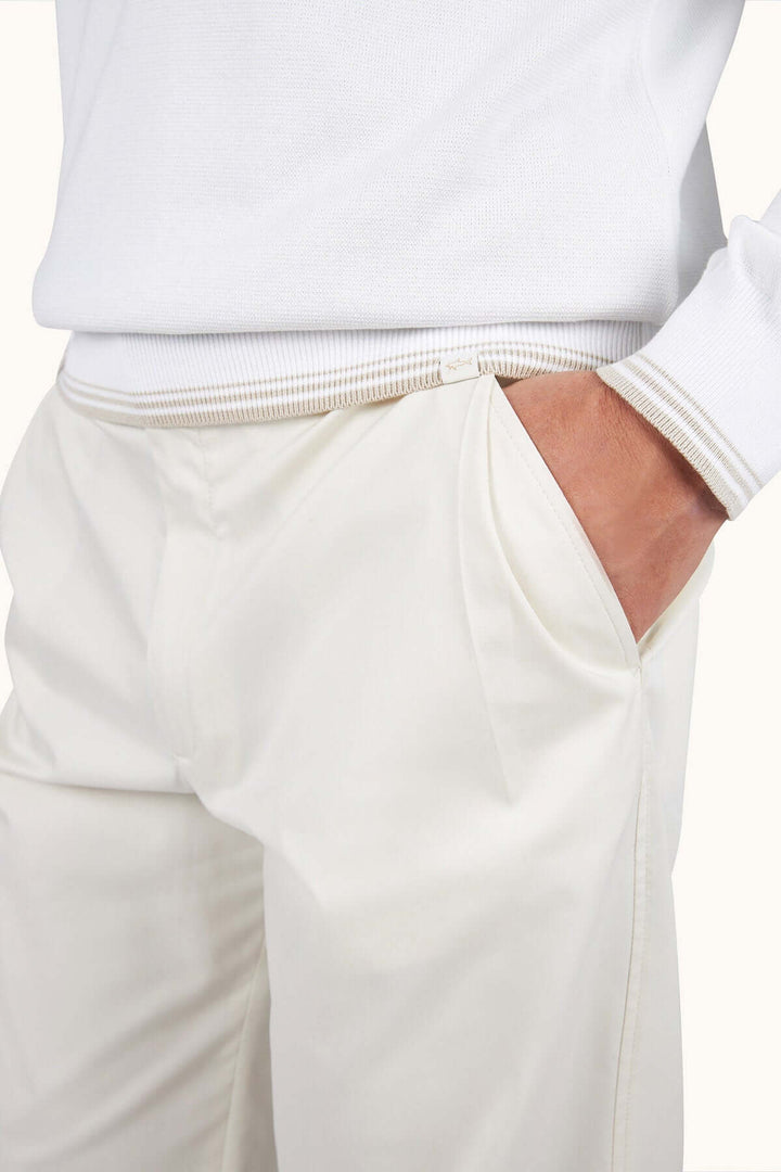 Pantalon blanc élégant avec main dans la poche, style moderne et décontracté pour un look chic.