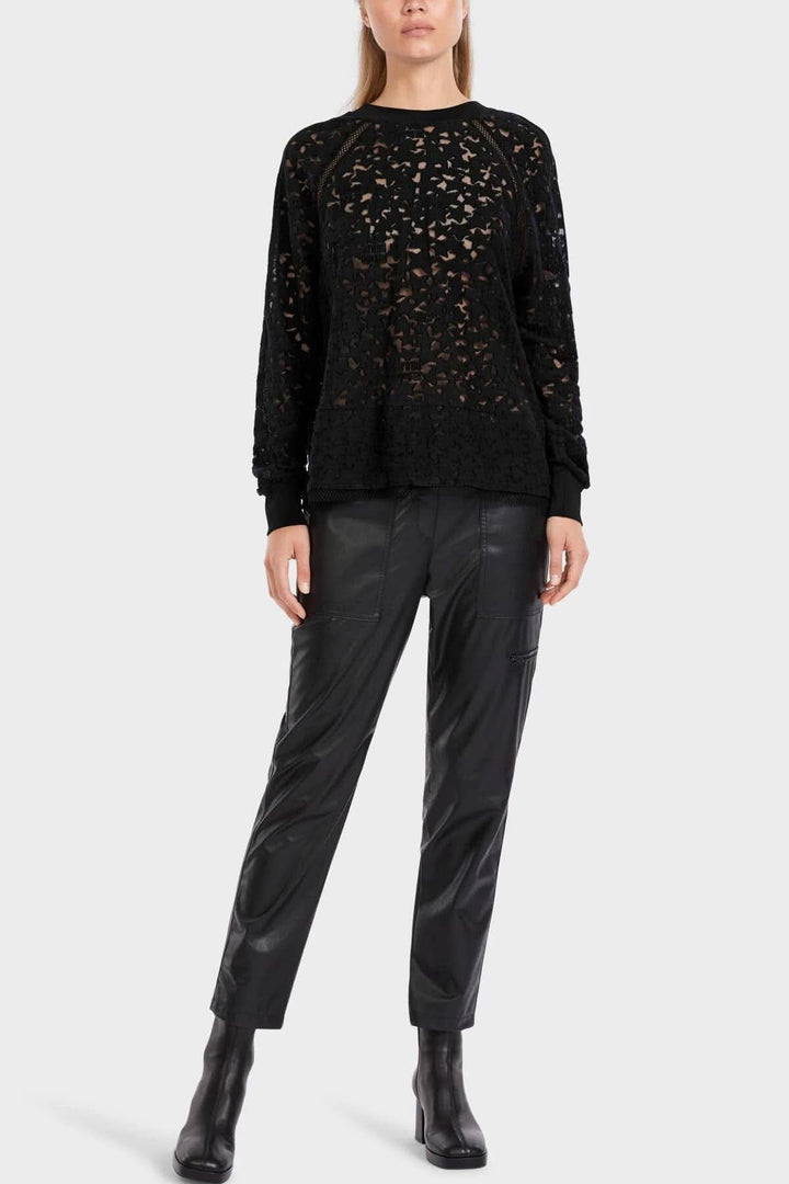 Chandail en dentelle noir avec manches longues, porté avec un pantalon en cuir, style minimaliste.