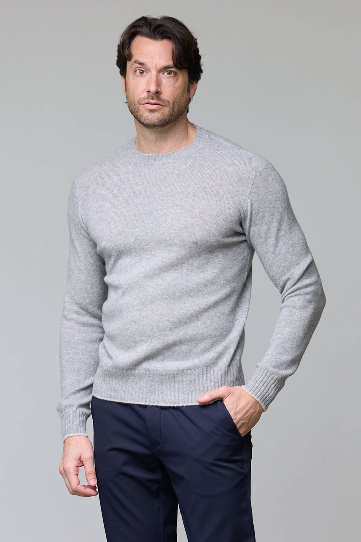 Homme portant un chandail en laine gris avec coupe ajustée et maille fine, parfait pour une allure sophistiquée.