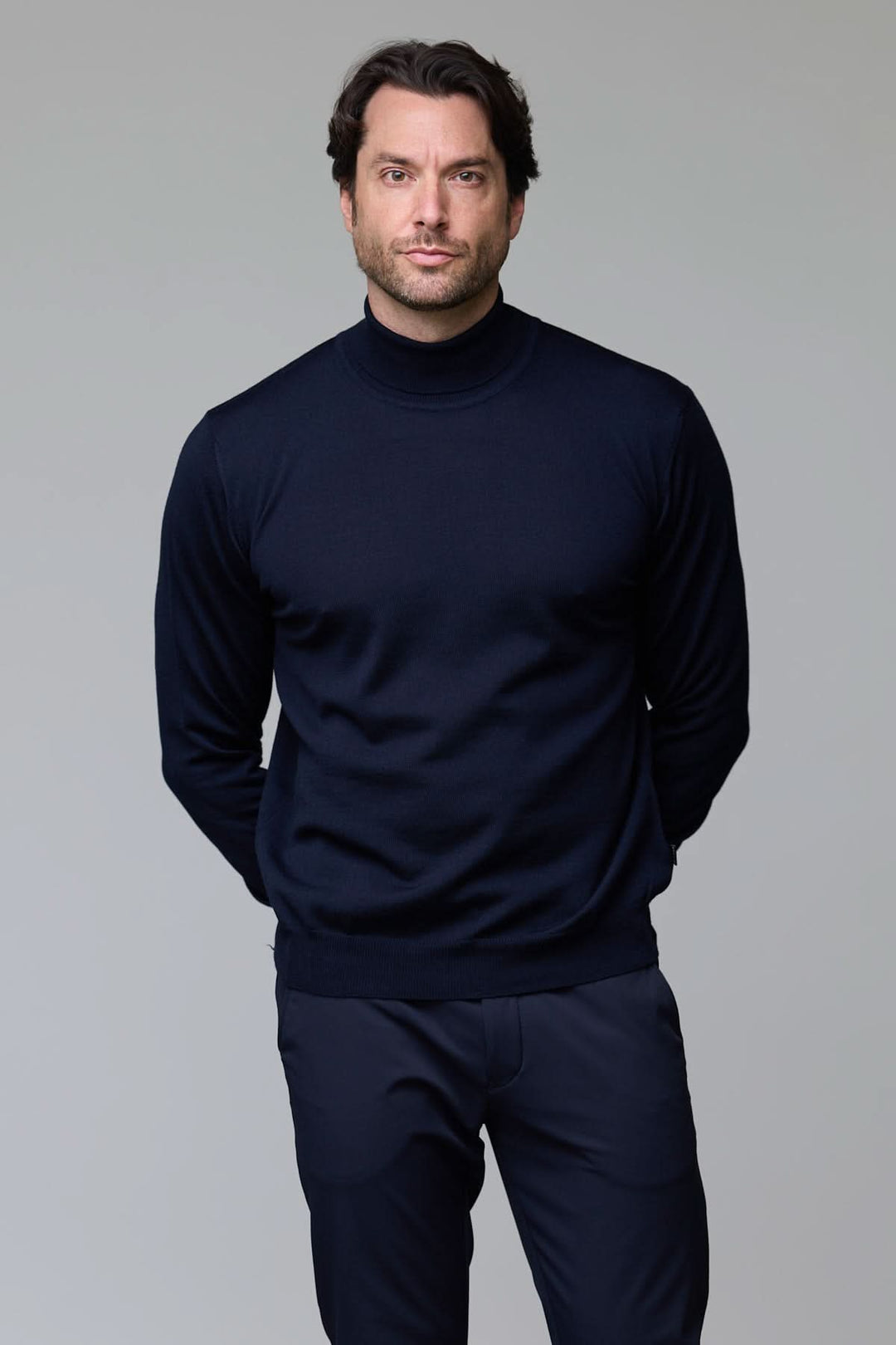 Homme portant un chandail en laine mérinos fine noir, col rond, coupe droite, allure sophistiquée.