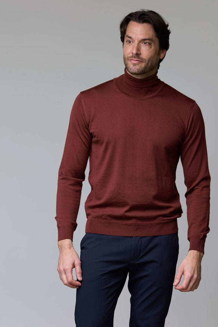 Homme portant un chandail en laine mérinos fine à col roulé, couleur marron, parfait pour un style intemporel et élégant.