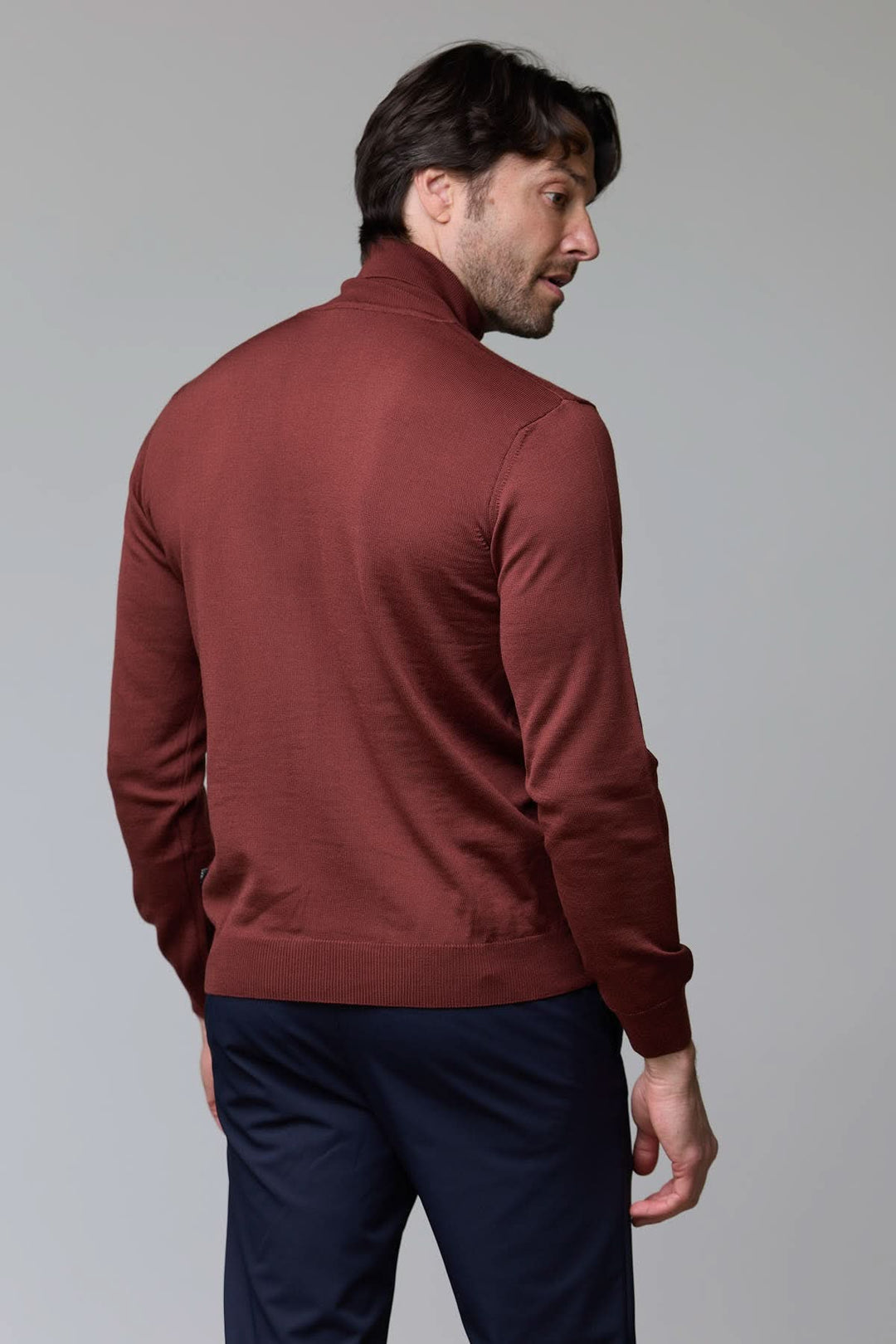 Homme portant un chandail en laine mérinos fine marron de dos, coupe droite élégante et col rond côtelé, confort et style intemporel.