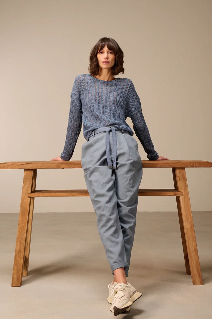 Femme portant un chandail en maille ajourée moderne et chic avec un style décontracté et léger, idéal pour la superposition.