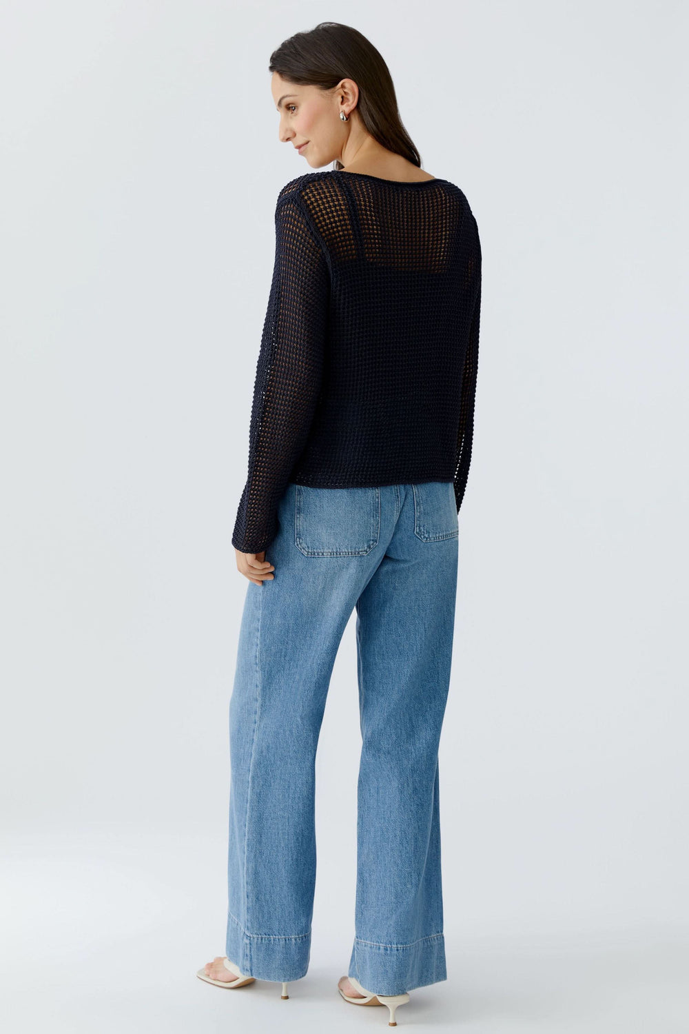 Femme portant un chandail en maille ajourée à manches longues, style moderne, coupe droite, sur jean, vue de dos.