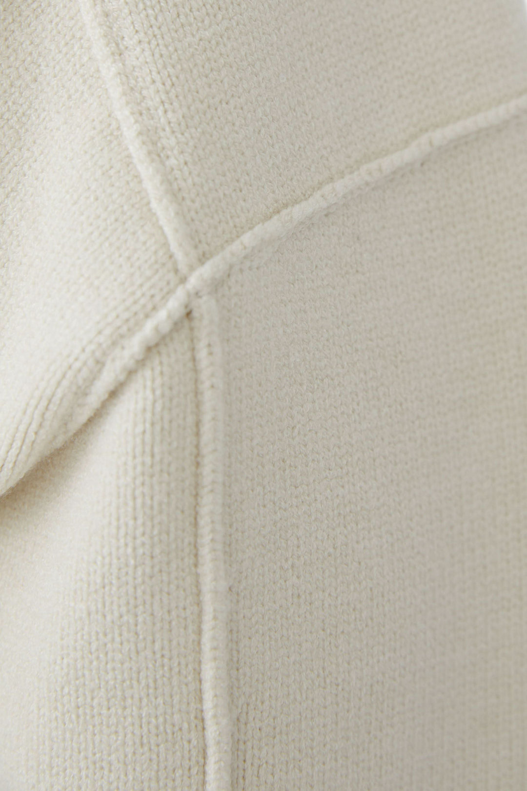 Détail du chandail en maille à col en V avec texture douce et couture visible pour un style raffiné et doux.