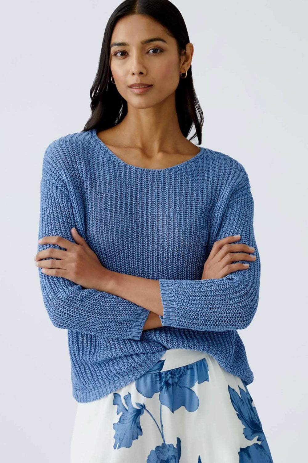 Chandail en maille côtelée bleu, à coupe décontractée, porté avec une jupe fluide à motifs.