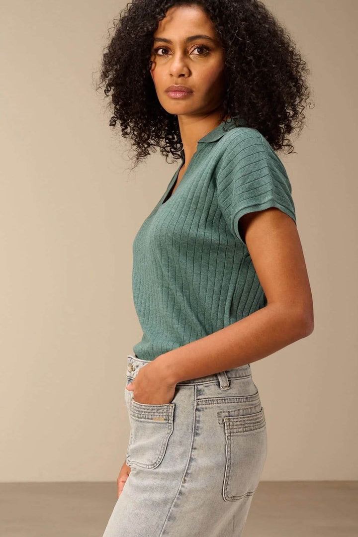 Chandail en maille fine côtelé, encolure V avec col polo, porté avec un jean, look moderne et polyvalent.