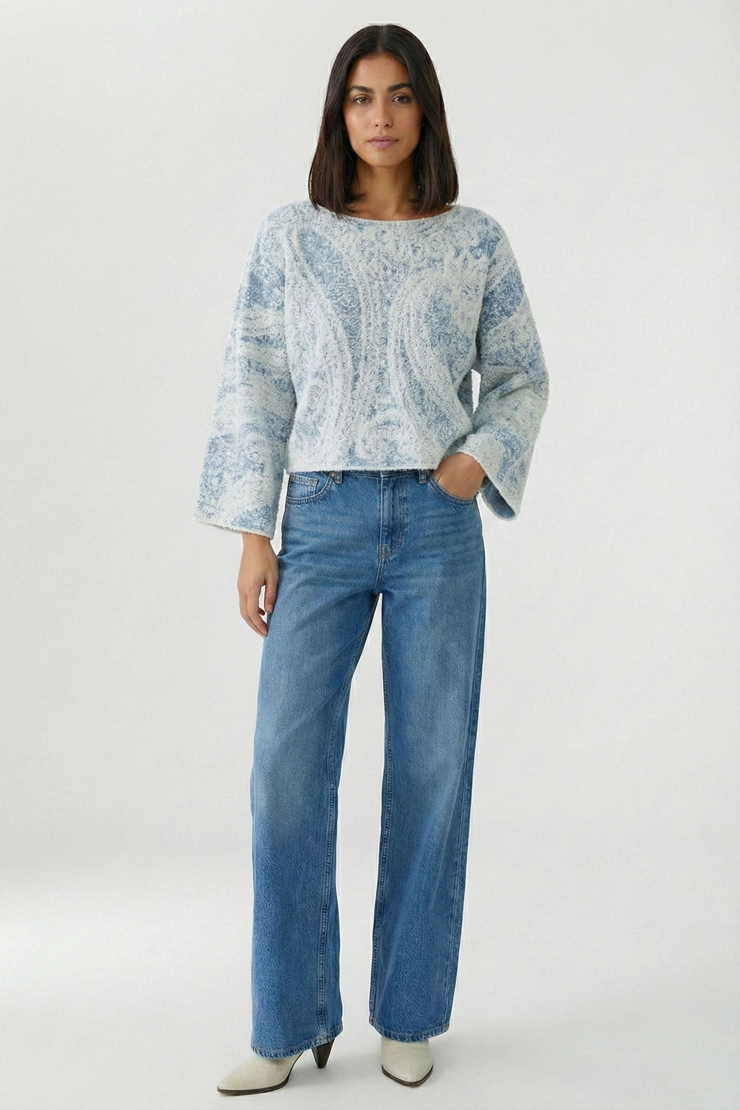Femme portant un Chandail en maille imprimée à manches larges avec motif cachemire et jean, look moderne et féminin.