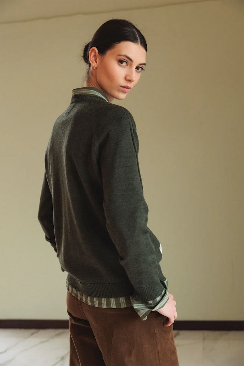 Chandail en mérinos à motif argyle modernisé, confortable et élégant, porté sur une chemise pour un look preppy-chic.