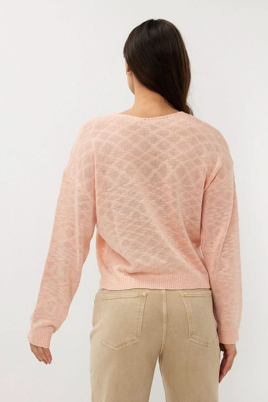 Chandail en tricot ajouré rose, coupe ample, col en V, manches longues, parfait pour un look décontracté.