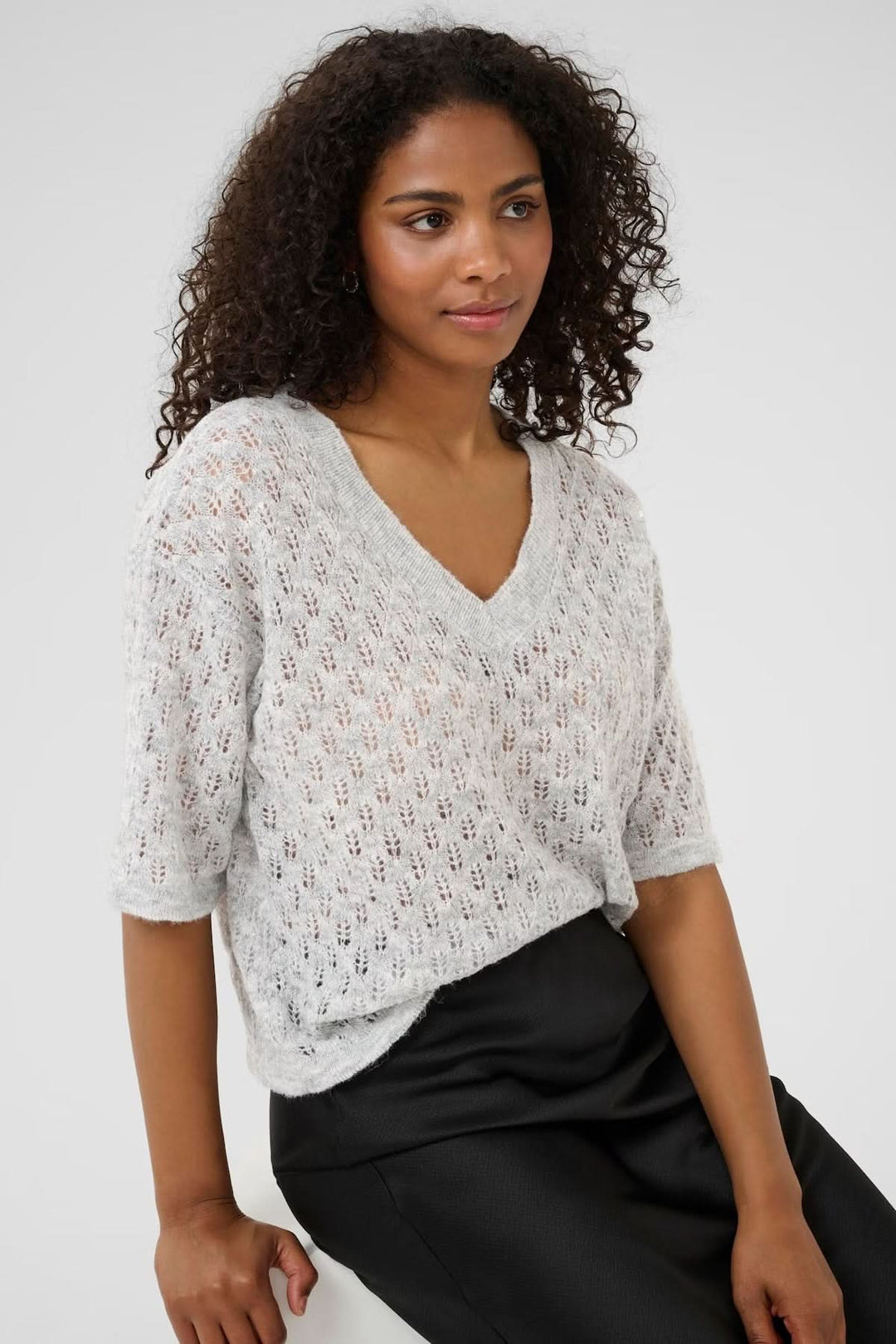 Chandail en tricot ajouré à col en V, léger et texturé, parfait pour un look féminin décontracté.