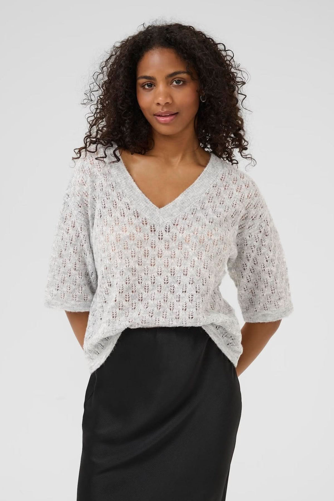 Chandail en tricot ajouré à col en V, avec manches courtes, pour un look léger et féminin.