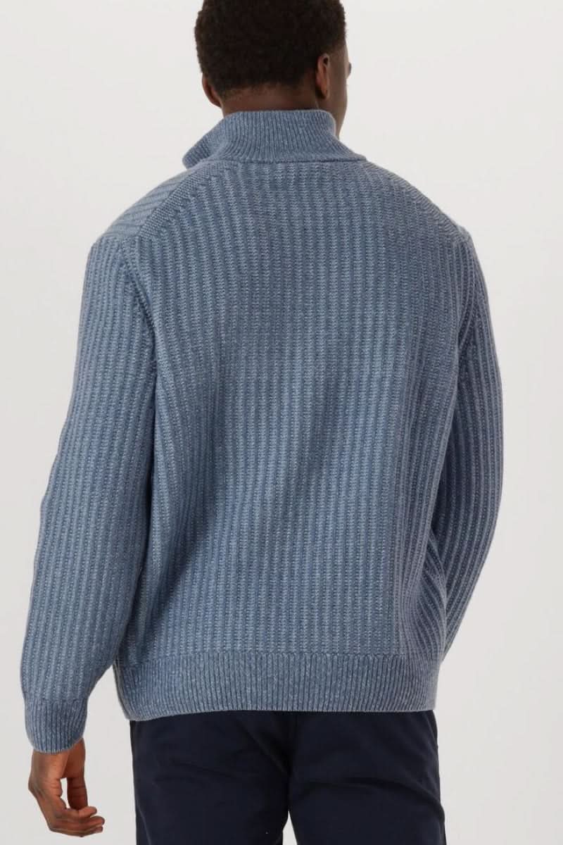 Homme portant un chandail en tricot à demi-glissière avec col montant zippé et design côtelé, idéal pour un style décontracté et soigné.