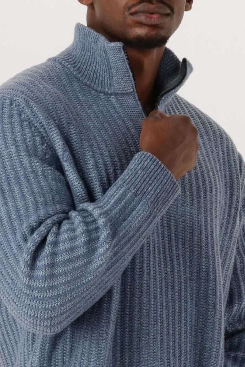 Homme portant un chandail en tricot à demi-glissière bleu avec col montant zippé et design côtelé classique.