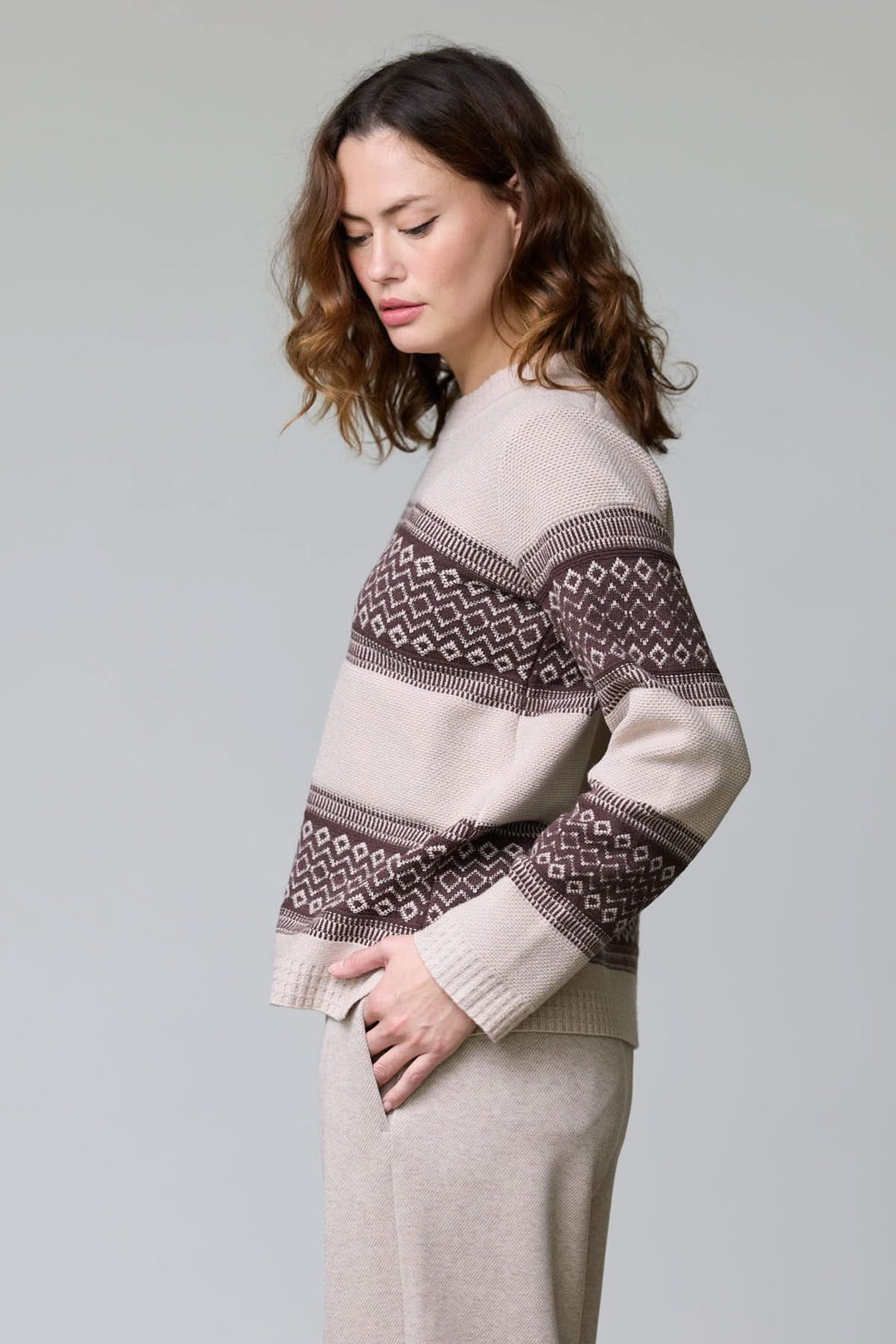 Femme portant un chandail en tricot jacquard avec motif géométrique bicolore et encolure ronde pour tenues d’hiver élégantes.