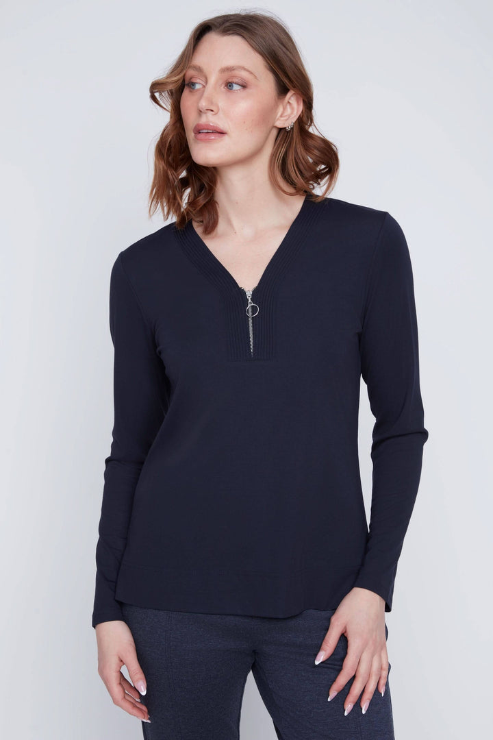 Femme portant un chandail encolure en V zippée, manches longues, design minimaliste, tissu extensible.